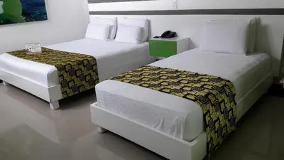 two beds sitting next to each other in a room at Hotel Genova Prado in Barranquilla