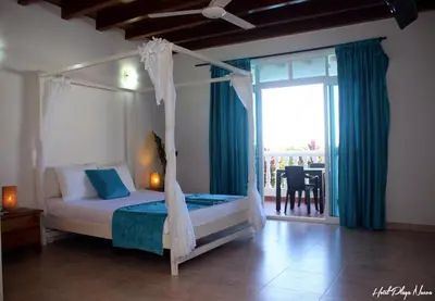 a bedroom with a canopy bed and a dining room at hotel 3 banderas Manzanillo del Mar in Cartagena de Indias
