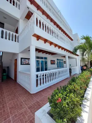 a building with a staircase and flowers in a courtyard at hotel 3 banderas Manzanillo del Mar in Cartagena de Indias