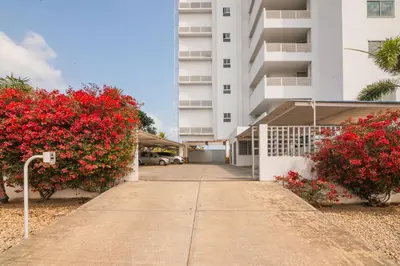 a sidewalk in front of a building with red flowers at Magico Apartamento Frente al Mar 3 Habitaciones AR91 in Pativilca