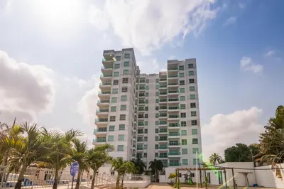 a tall building with palm trees in front of it at Magico Apartamento Frente al Mar 3 Habitaciones AR91 in Pativilca