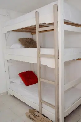 a bunk bed with white bunk beds in a room at Hostal Marbella 47 in Cartagena de Indias