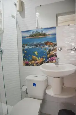 a bathroom with a sink and a toilet and a painting at Hostal Marbella 47 in Cartagena de Indias