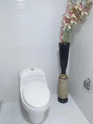 a bathroom with a toilet and a vase with flowers at Apartamento ideal en Cartagena in Cartagena de Indias