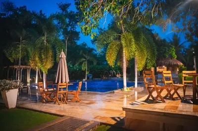 a patio with chairs and an umbrella and a pool at La Bonita Luxury Ecohotel in Sahagún