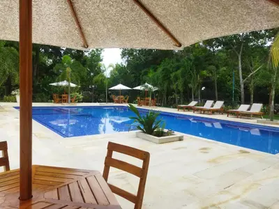 a pool with chairs and tables and an umbrella at La Bonita Luxury Ecohotel in Sahagún