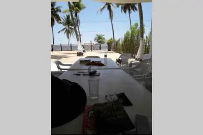 a white table with chairs and palm trees on the beach at PLAYA BLANCA SANANTERO CORDOBA las palmeras D’JC in San Antero