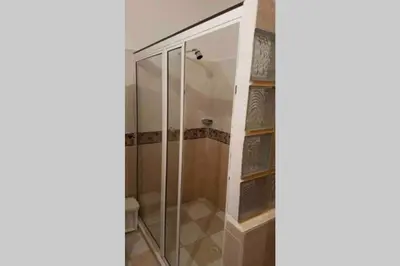 a shower with a glass door in a bathroom at PLAYA BLANCA SANANTERO CORDOBA las palmeras D’JC in San Antero