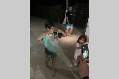 a young boy taking a picture of a little girl at PLAYA BLANCA SANANTERO CORDOBA las palmeras D’JC in San Antero