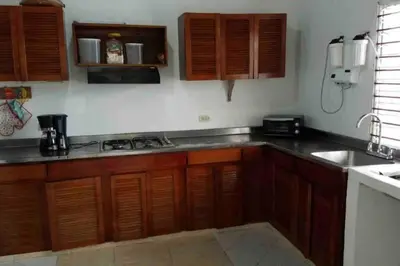 a kitchen with wooden cabinets and a stove top oven at PLAYA BLANCA SANANTERO CORDOBA las palmeras D’JC in San Antero