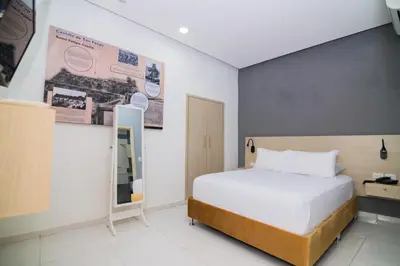 a bedroom with a white bed and a blue wall at Hotel Gallery Cartagena in Cartagena de Indias