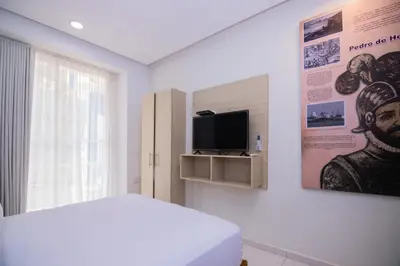a bedroom with a bed and a tv on a wall at Hotel Gallery Cartagena in Cartagena de Indias