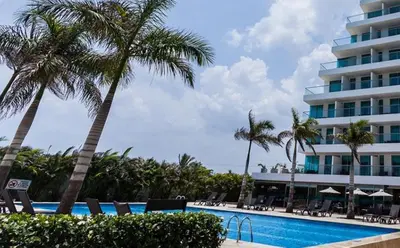 a swimming pool with palm trees and a hotel at Apartamento dentro del Hotel Sonesta Cartagena, aprovecha estar en lo mejor de MORROS in Cartagena de Indias
