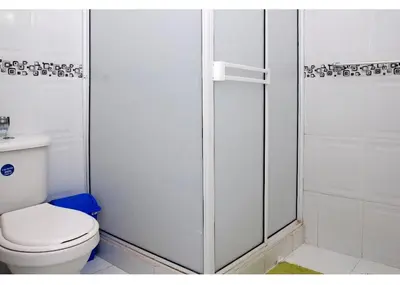 a white bathroom with a toilet and a shower at III NICE 2 BEDROOM APARTMENT Bocagrande in Cartagena de Indias