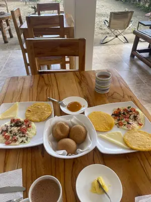 a wooden table with plates of food on it at älanacasadeplaya in San Bernardo del Viento