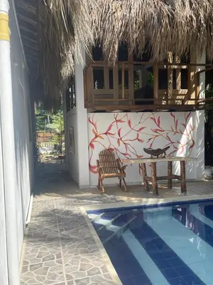 a bench next to a building with a swimming pool at älanacasadeplaya in San Bernardo del Viento