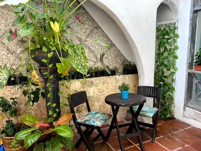 a table and chairs in front of a wall with plants at Luna Cartagena Airport Hotel in Cartagena de Indias