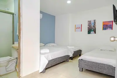 a room with two beds and a mirror at Luna Cartagena Airport Hotel in Cartagena de Indias