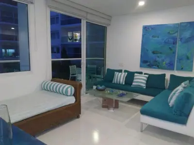 a living room with two couches and a table at Cartagena primera línea de playa azul frente al mar in Cartagena de Indias