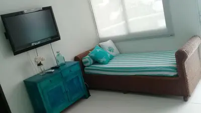 a living room with a couch and a tv at Cartagena primera línea de playa azul frente al mar in Cartagena de Indias