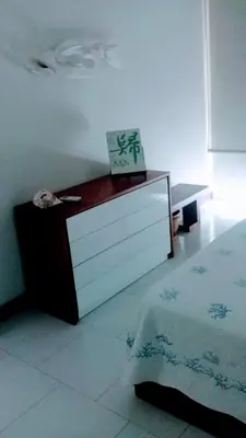 a bedroom with a bed and a dresser with a box on it at Cartagena primera línea de playa azul frente al mar in Cartagena de Indias
