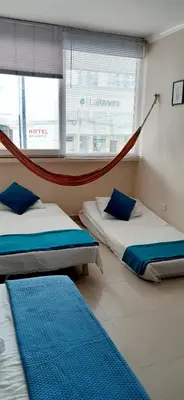 a room with two beds and a hammock in it at Apto Nacaela-Bocagrande cerca a la playa in Cartagena de Indias