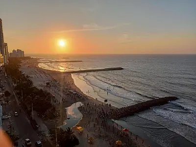 a beach with a crowd of people at sunset at Apto Nacaela-Bocagrande cerca a la playa in Cartagena de Indias