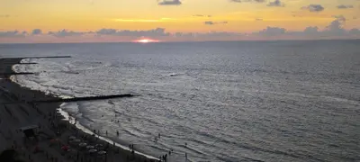a sunset over the ocean with a sandy beach at apartaestudio al lado del mar in Cartagena de Indias