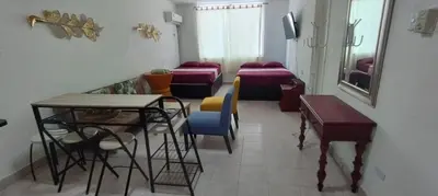a waiting room with beds and a table and chairs at apartaestudio al lado del mar in Cartagena de Indias