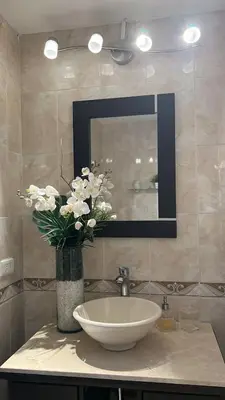 a bathroom with a sink and a vase of flowers at SOL, ARENA, MAR, y PISCINA in Cartagena de Indias