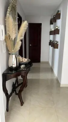 a hallway with a table with a vase with feathers on it at SOL, ARENA, MAR, y PISCINA in Cartagena de Indias