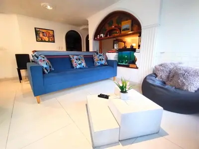 a living room with a blue couch and a table at HOMEthel in Cartagena de Indias