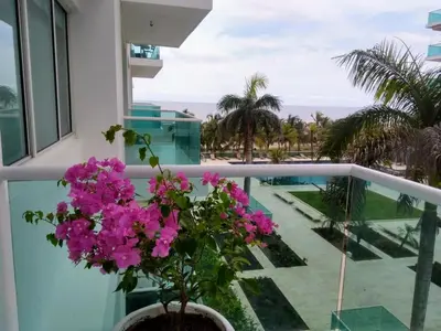 a balcony with pink flowers and a view of the ocean at Apartamento con excelente vista al mar Dos alcobas los Morros in Cartagena de Indias