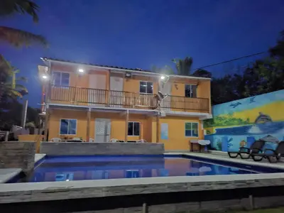 a house with a swimming pool in front of a building at Cabaña frente al mar en moñitos, córdoba in Moñitos