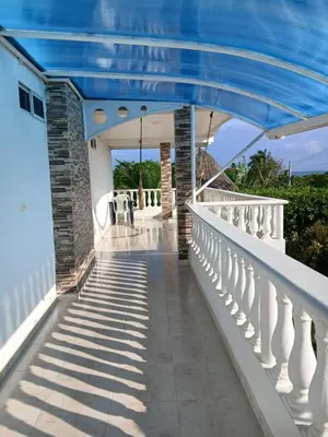 a balcony of a house with a blue roof at Cabaña Villa Carmen in Juan de Acosta