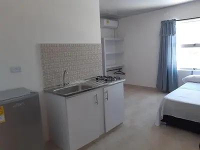 a kitchen with a sink and a bed in a room at Cabaña Villa Carmen in Juan de Acosta