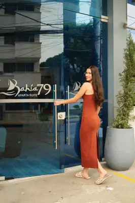 a woman in a red dress standing in front of a store at Suite con balcón cerca al centro Cartagena in Cartagena de Indias