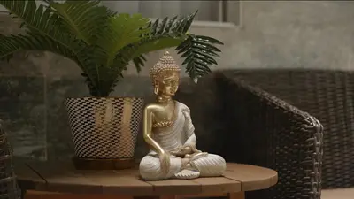 a statue sitting on a table next to a potted plant at Suite con balcón cerca al centro Cartagena in Cartagena de Indias