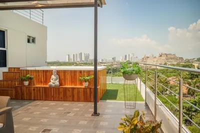 a balcony with a buddha statue sitting on a bench at Suite con balcón cerca al centro Cartagena in Cartagena de Indias