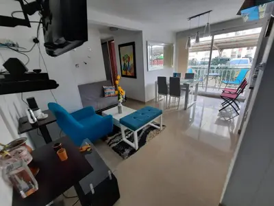 a living room with a blue couch and a table at Apto cómodo, confortable para descansar y Disfrutar in Cartagena de Indias