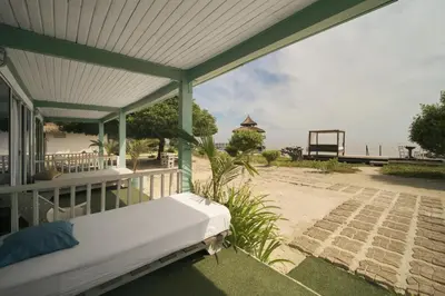 a bed on the porch of a beach house at El Embrujo Tintipan in Tintipan Island