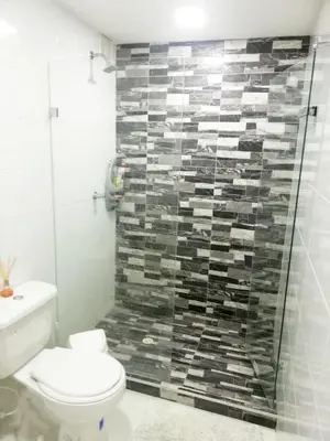 a bathroom with a toilet and a glass shower at Hermoso apartamento frente al Mar Caribe in Cartagena de Indias