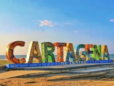 a large sign on the beach with the ocean in the background at Hermoso apartamento frente al Mar Caribe in Cartagena de Indias
