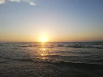 a sunset on the beach with the ocean at Hermoso apartamento frente al Mar Caribe in Cartagena de Indias