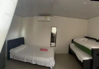 a room with two beds and a mirror in it at sophia house in Cartagena de Indias