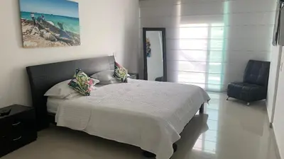 a bedroom with a large bed and a chair at MORROS ULTRA APTO 706 in Cartagena de Indias
