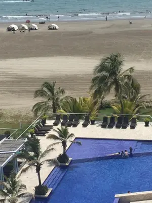 a swimming pool next to a beach with palm trees at MORROS ULTRA APTO 706 in Cartagena de Indias