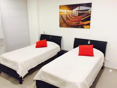 two beds in a room with red pillows on them at MORROS ULTRA APTO 706 in Cartagena de Indias