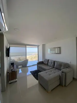 a living room with a couch and a large window at Vista mar!! in Cartagena de Indias