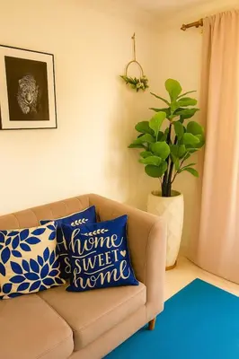 a living room with a couch with blue and white pillows at Casa MIKONOS in Cartagena de Indias